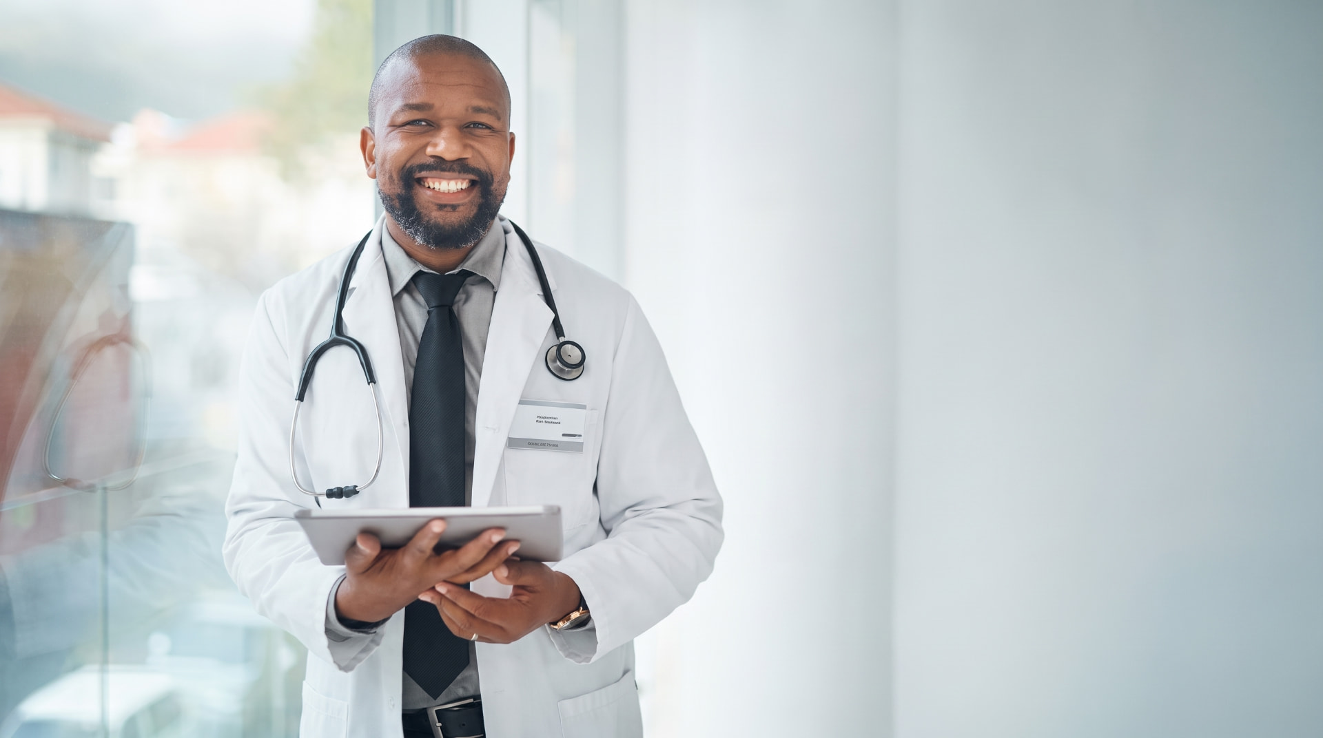 Physician holding a tablet in a bright clinic